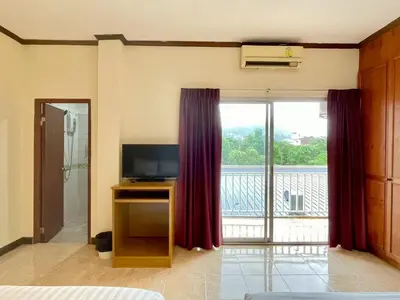 a room with a television and a large window at Maap Guest House in Patong Beach