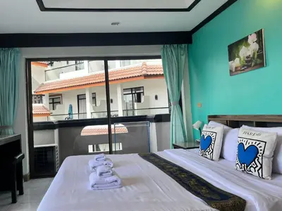 a bedroom with a bed with a large window at NR Nanai Patong in Patong Beach