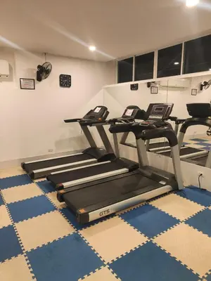 a gym with three treadmills in a room at Relaxing Apartment in Karon in Karon Beach