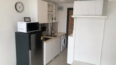 a kitchen with a black refrigerator and a microwave at Cozy studio Sunset view near of MaiKhao beach in Ban Mai Salae