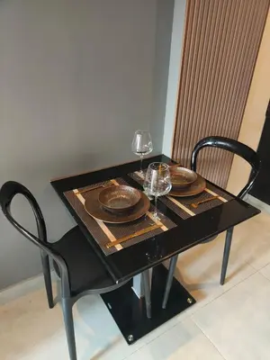 a black table with two glasses and plates on it at Modern Apartment in Chalong in Chalong