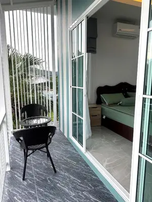 a room with a balcony with a chair and a bed at Villa Sea View PanWa in Ko Taphao Noi