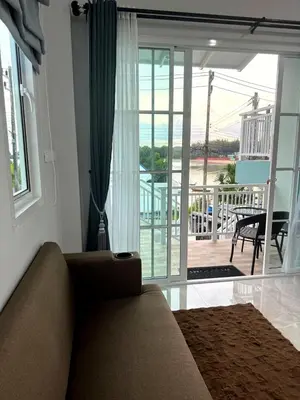a living room with a couch and a sliding glass door at Villa Sea View PanWa in Ko Taphao Noi