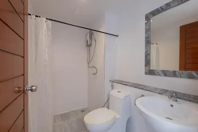 a bathroom with a toilet and a sink and a mirror at Baan KetKaew Patong in Patong Beach