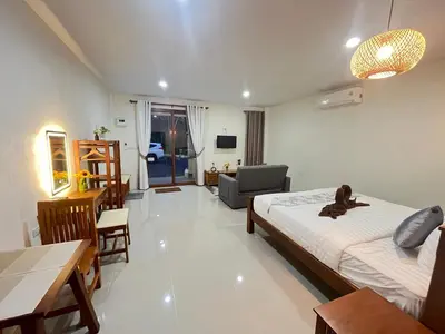 a bedroom with two beds and a living room at The wells house krabi in Klong Muang Beach