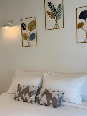 a white bed with three pictures on the wall at Sea Escape Koh Yao Yai in Ko Yao Yai