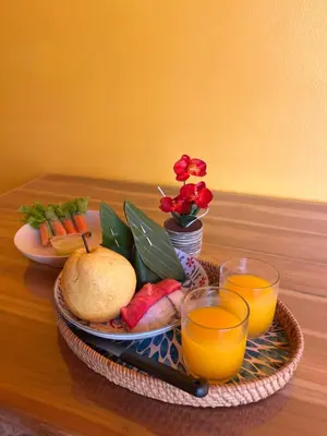 a tray of fruit and vegetables and two glasses of orange juice at SeaMountain Kohyao Noi in Ko Yao Noi