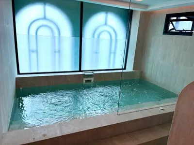a large tub with a glass window in a bathroom at The Legendary Apartment 408 in Bang Tao Beach