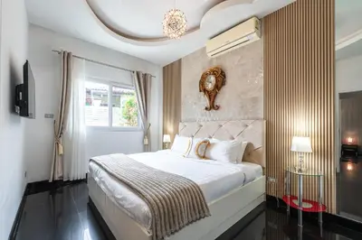 a bedroom with a bed with a clock on the wall at Platinum Villa Rawai 76 in Rawai Beach