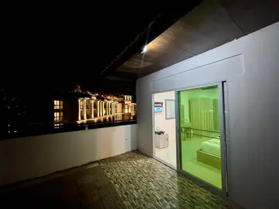 a room with a bathroom with a window with a view at LimeTree Loft Guesthouse in Patong Beach
