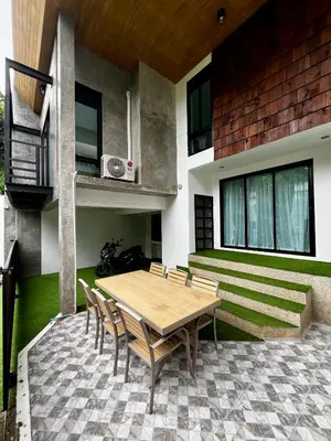 a wooden table and chairs in front of a building at Private 2-Bedroom Pool Villa in Rawai, Phuket in Rawai Beach