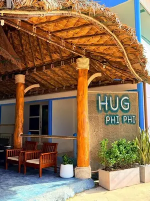 a restaurant with two benches under a pergola at HUG PHIPHI Resort in Phi Phi Don