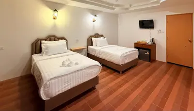 a hotel room with two beds and a television at HUG PHIPHI Resort in Phi Phi Don