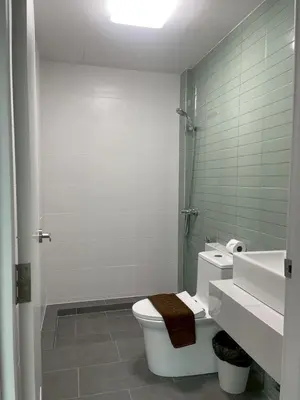 a white bathroom with a toilet and a sink at Salty Sand Krabi Hotel in Ban Khlong Haeng