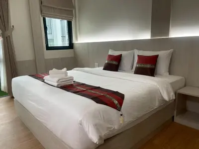 a bedroom with a large white bed with red pillows at Salty Sand Krabi Hotel in Ban Khlong Haeng