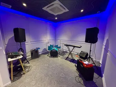 a room with purple walls and a stage with equipment at The Legendary Apartment 209 in Bang Tao Beach
