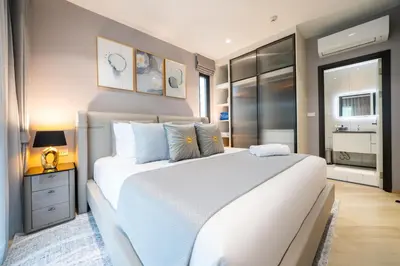 a bedroom with a large white bed with blue pillows at The Legendary Apartment 209 in Bang Tao Beach
