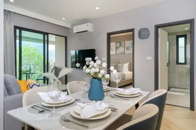 a dining room with a white table and chairs at The Legendary Apartment 209 in Bang Tao Beach