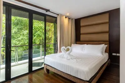 a bedroom with a bed with white sheets and a window at Beautiful Patong Sea View 6 Bedroom Thai Luxury Villa Near Bar Street, Jungceylon in Patong Beach