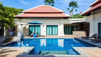 a villa with a swimming pool in front of a house at Genesis Elephant Villa in Rawai Beach