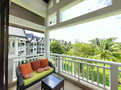 a screened porch with a bench and a view of the ocean at Apartment 2 bedrooms in Allamanda in Laguna Phuket