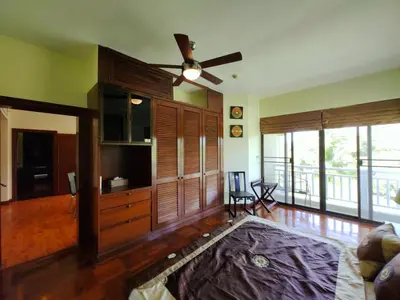 a living room with wooden cabinets and a ceiling fan at Apartment 2 bedrooms in Allamanda in Laguna Phuket