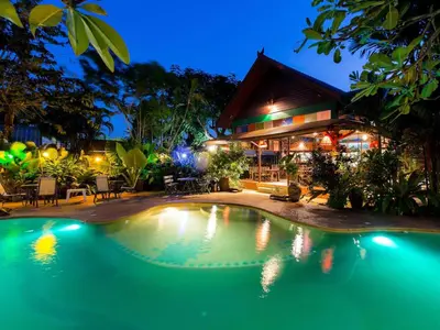 a swimming pool in front of a house at night at OASIS by Four Twenty in Chalong