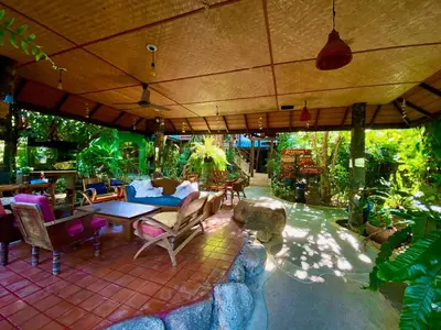 an outdoor patio with a table and chairs at OASIS by Four Twenty in Chalong