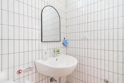 a white bathroom with a sink and a mirror at Cozy Home in heart of Patong in Patong Beach