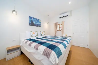 a bedroom with a bed with a blue and white blanket at Cozy Home in heart of Patong in Patong Beach