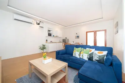 a living room with a blue couch and a table at Cozy Home in heart of Patong in Patong Beach
