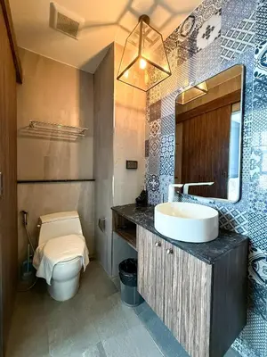 a bathroom with a sink and a toilet and a mirror at Palmyrah Surin Apartments by Mill in Surin Beach