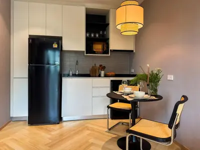 a kitchen with a black refrigerator and a table with chairs at Modern 1BR with Pool View The Title Legendary in Bang Tao Beach