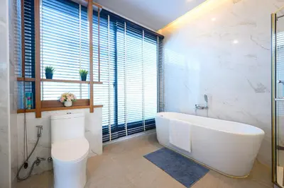 a bathroom with a white tub and a toilet at New Luxury Pool Villa Bangtao Phuket in Ban Pak Lak
