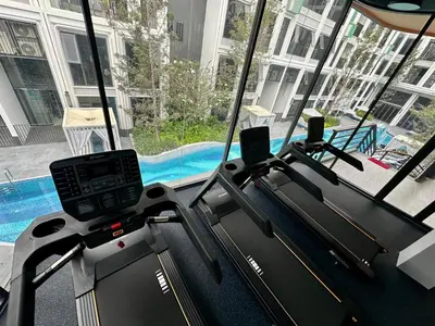 a gym with two treadmill machines and a pool at Bangtao new studio in Bellevue Lagoon in Laguna Phuket