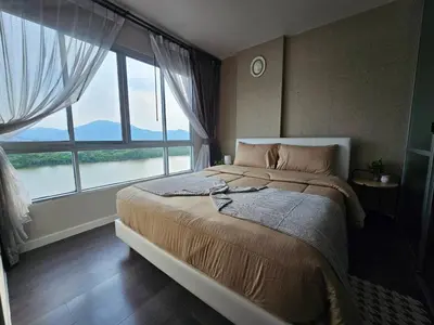 a bedroom with a large bed with a large window at The Azure Kathu in Kathu