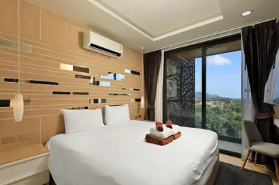a hotel room with a bed and a window at Stylish apartments in Calypso Garden condo, Sea View! in Rawai Beach