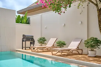 two lounge chairs sitting next to a swimming pool at Villa Moana 2BR Private Pool Naiharn beach in Rawai Beach