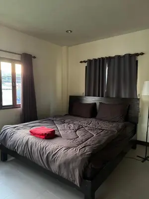 a bed in a bedroom with a red shirt on it at Kamala Charming Local House near Kamala Beach in Kamala Beach