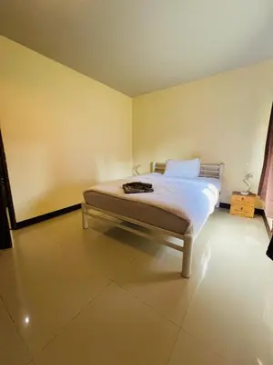 a bedroom with a bed and a yellow wall at Kamala Charming Local House near Kamala Beach in Kamala Beach