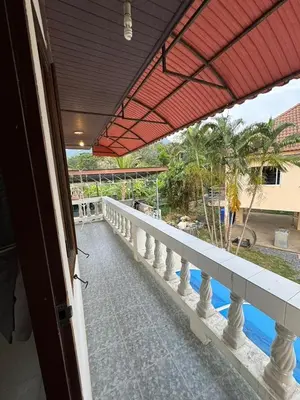 a balcony with a view of the ocean and palm trees at Kamala Charming Local House near Kamala Beach in Kamala Beach