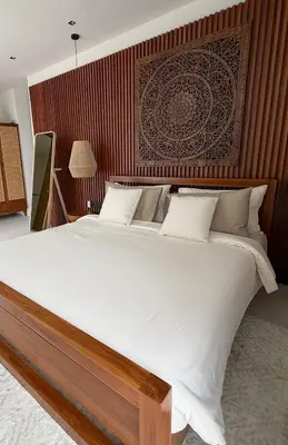 a bedroom with a large bed with a wooden headboard at Lake View Landscape Modern villa Bang Tao in Ban Thalat Choeng Thale