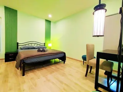 a bedroom with a bed and a desk and a chair at Palm Garden house 1 close to Bang Tao beach in Ban Phak Chit