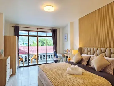 a bedroom with a large bed and a balcony at 4 bedroom Lucky House Patong in Patong Beach