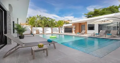 a swimming pool with a table and chairs next to a house at Stunning Pool Villa Curtis - 5 Bedrooms in the heart of Rawai in Rawai Beach