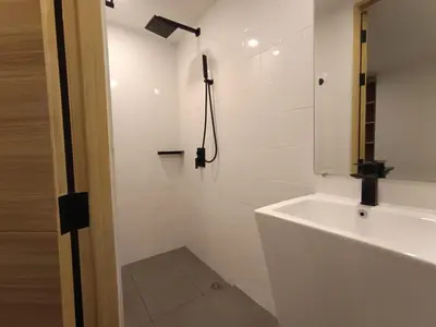 a white bathroom with a sink and a shower at Utopia Lofts by Sabai Sands in Nai Harn Beach