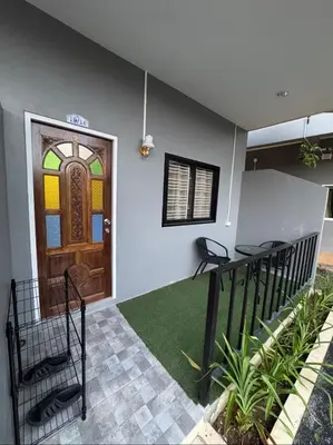 a front door of a house with a green rug at Palai House in Ban Na Bon
