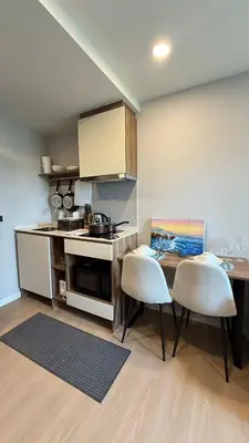 a kitchen with a table and two chairs in a room at Space Cherngtalay Condo in bangtao by sahana in Bang Tao Beach