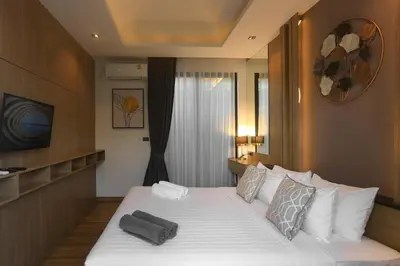 a bedroom with a large white bed with pillows at Holiday Villa M9 with Private Pool, 300m Rawai beach in Phuket Town