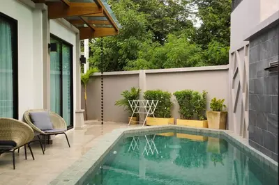 a swimming pool in a patio with chairs and a table at Tropical villa Sweet Dreams R20, Private Pool, Rawai Beach in Phuket Town